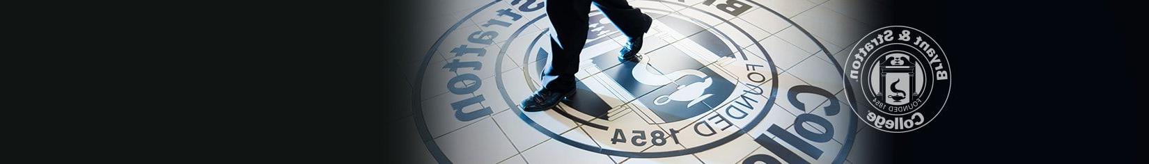 Student walking across 布赖恩特 and Stratton seal on campus floor